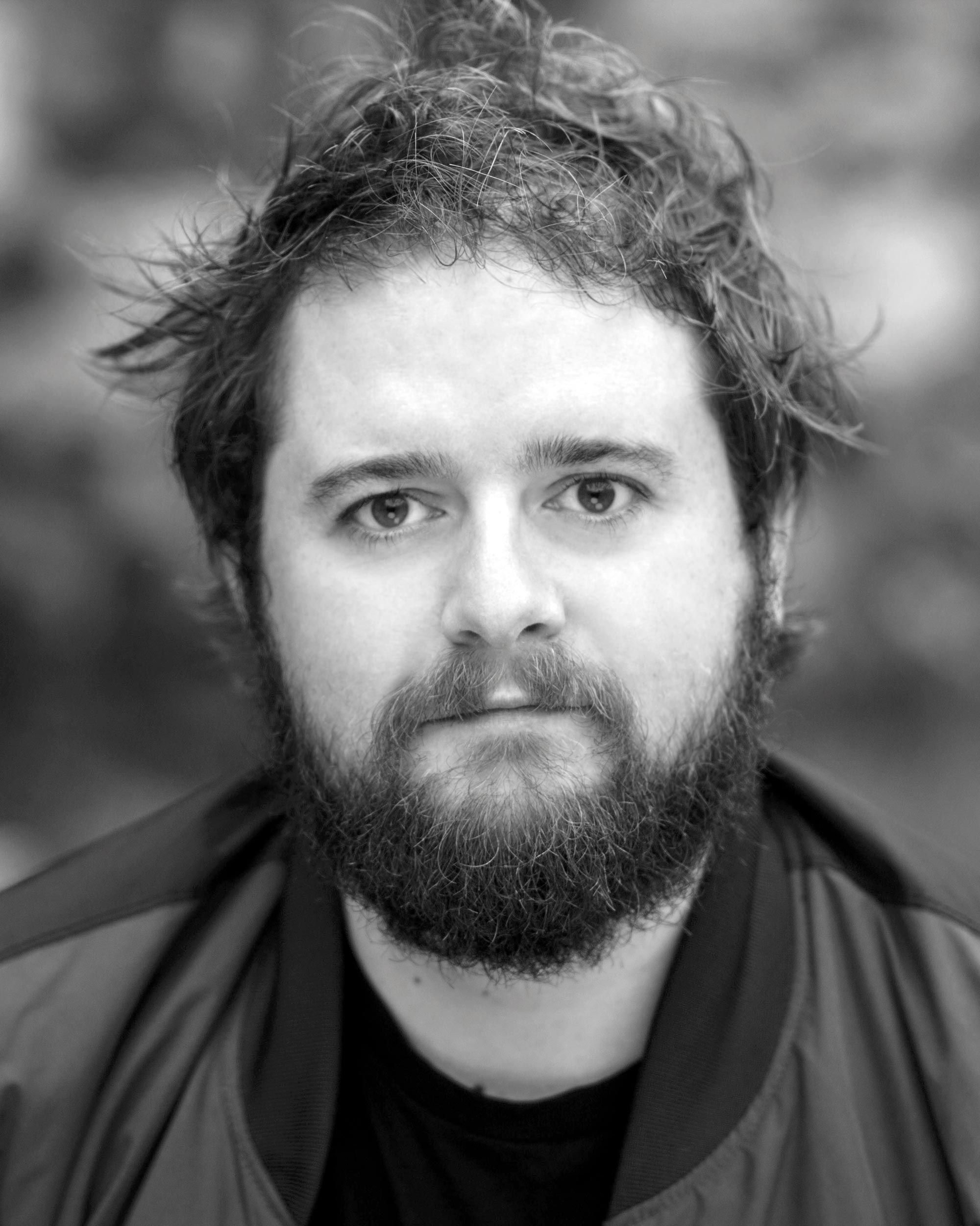 Head and shoulders portrait of Allan Clayton looking to camera