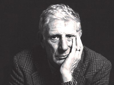 Jonathan-Miller, resting his head on his hand looking to camera