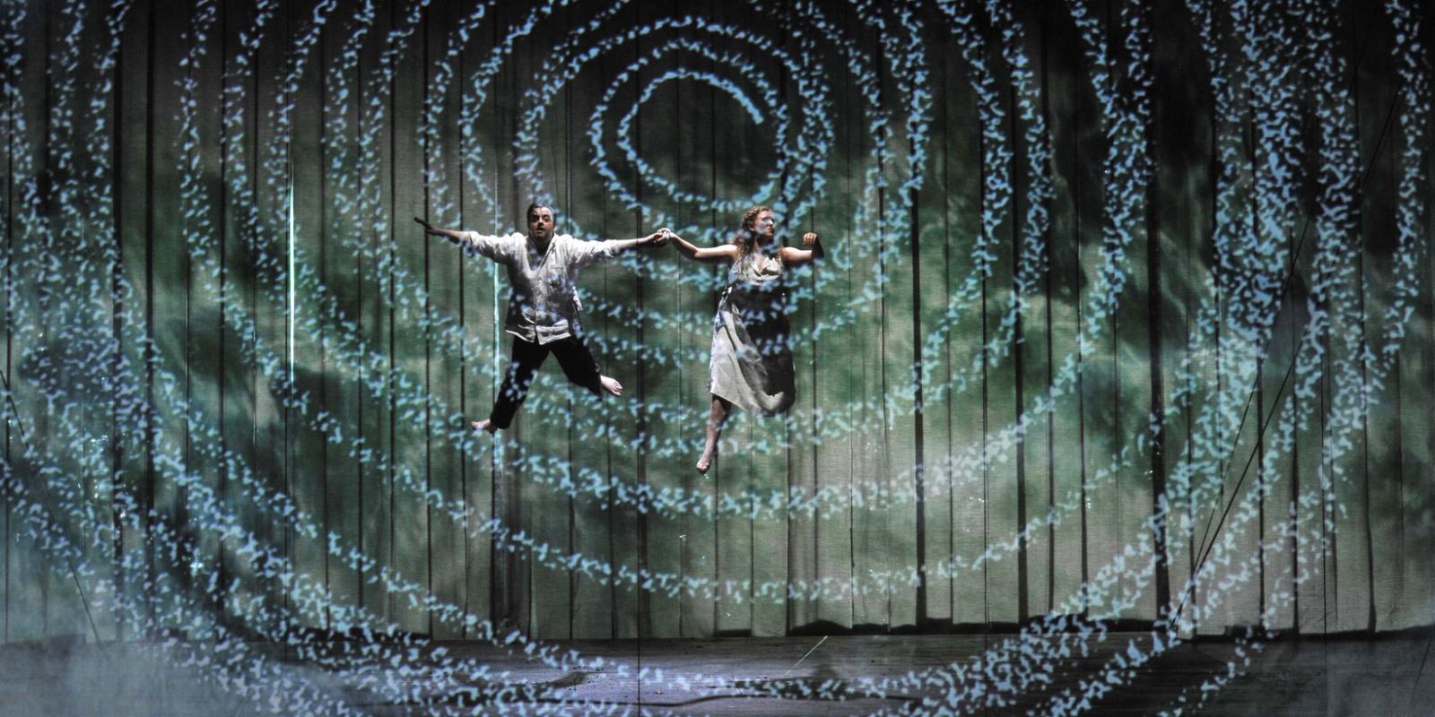 man and woman suspended in mid air over the stage in the magic flute