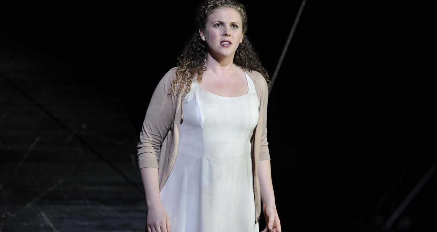 Woman in a white dress facing the audience in ENO's The Magic Flute