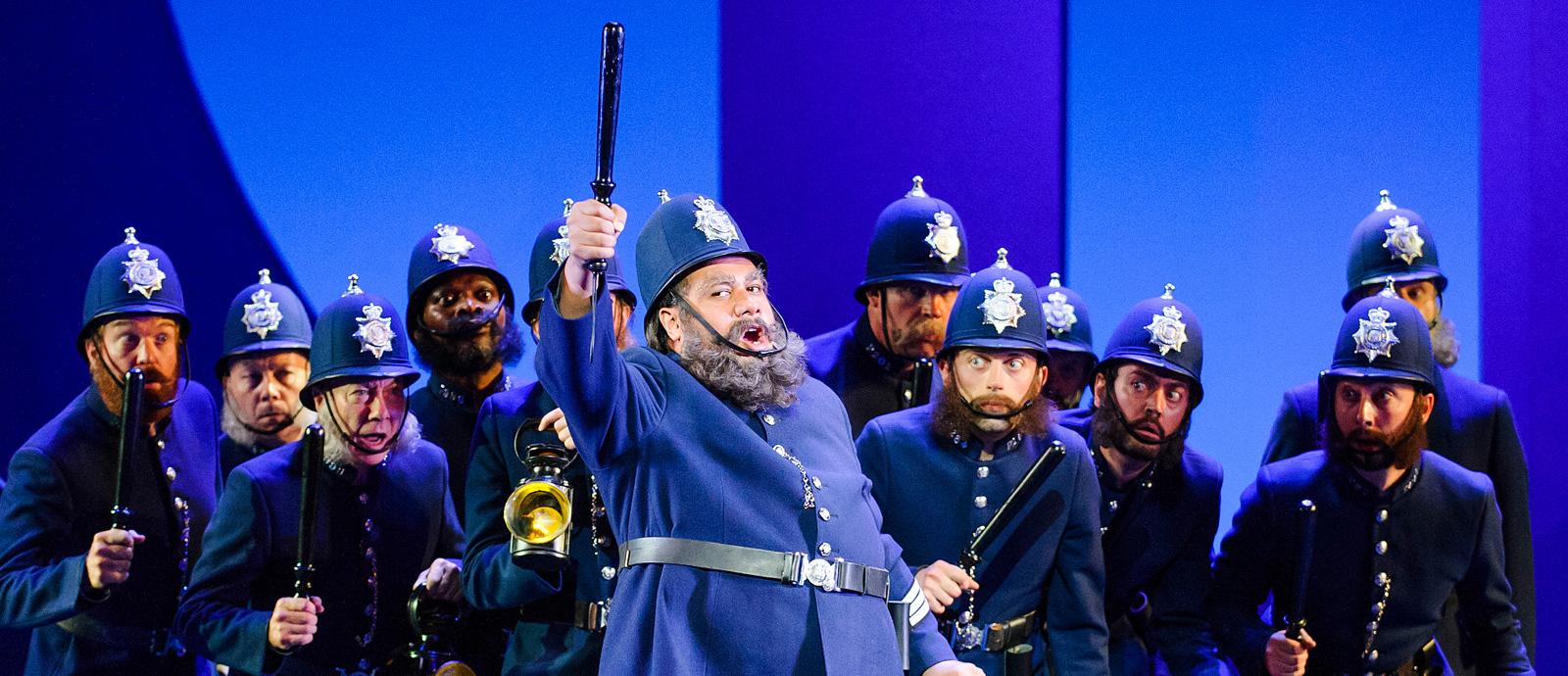 ENO's The Pirates of Penzance - Jonathan Lemalu as Sergeant of Police and Company. Photo by Tristram Kenton