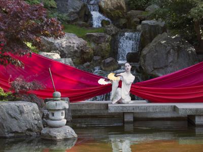 character from madam butterfly by a lake wrapped in big red ribbon