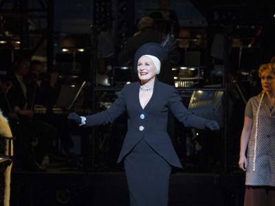 glenn close in a black suit performing on stage