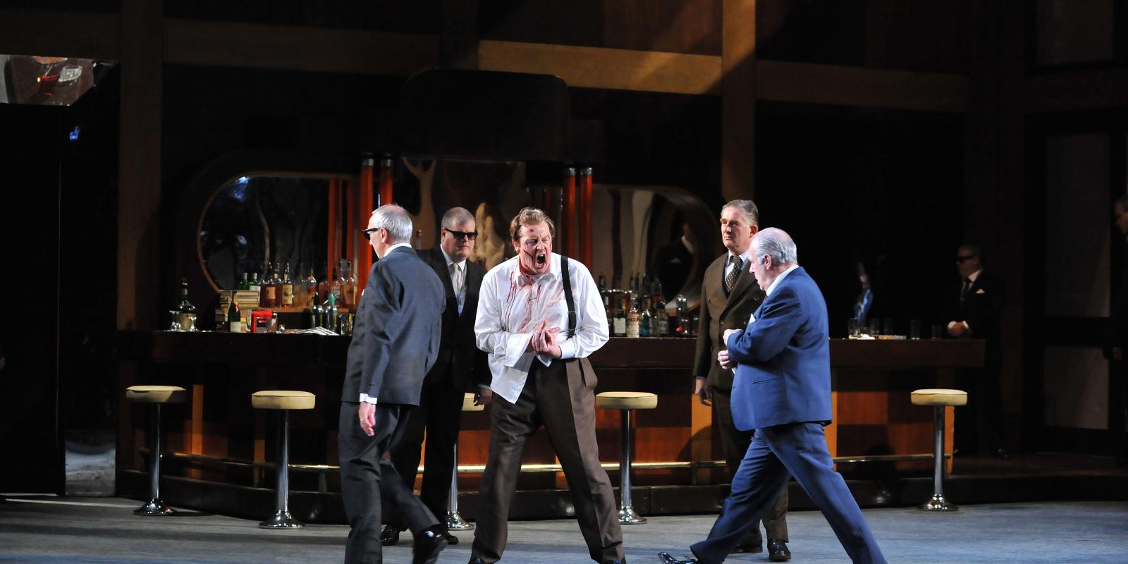 men in suits performing on stage in rigoletto