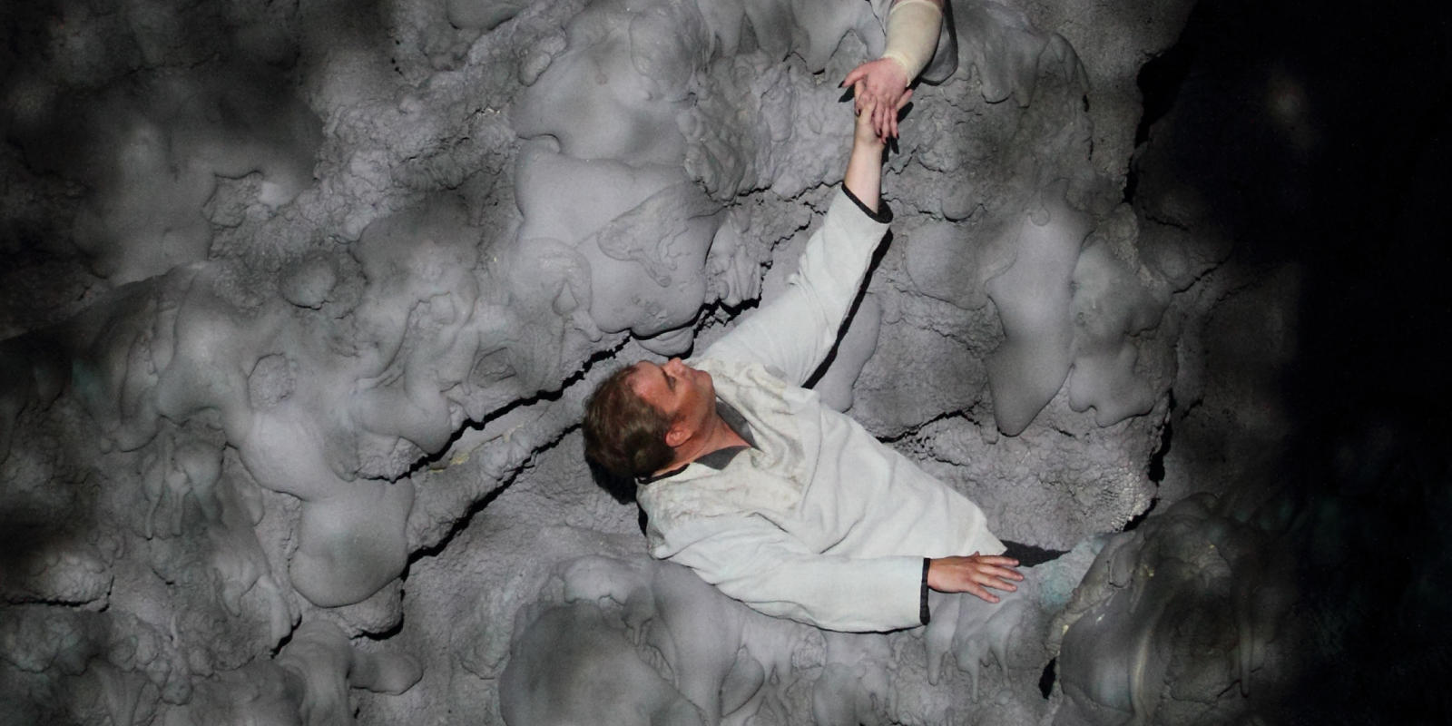 above shot of man and woman in grey foam as part of ENO's Tristan and Isolde