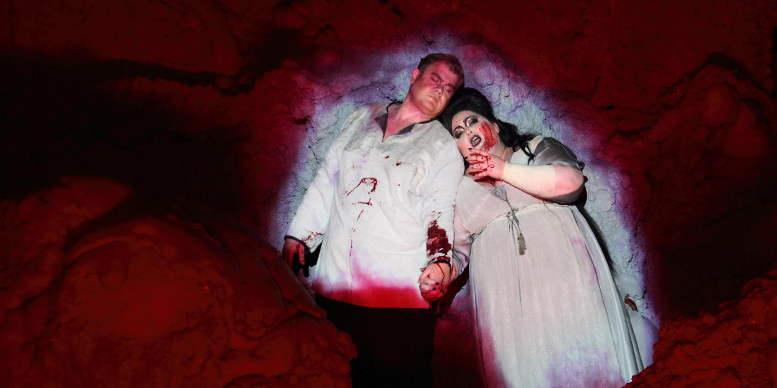 man and woman covered in blood lying on the floor from ENO's Tristan and Isolde