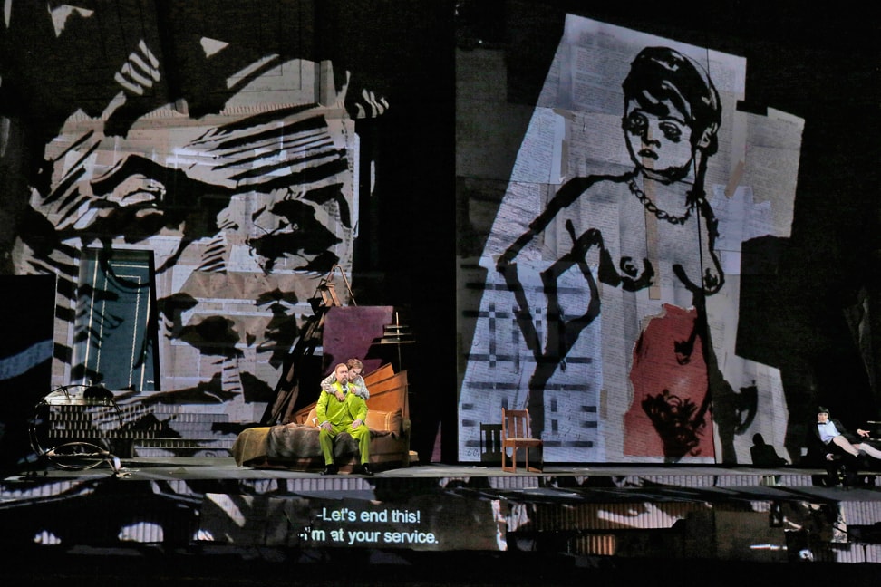 two people sat on a bed with graphic drawings projected behind
