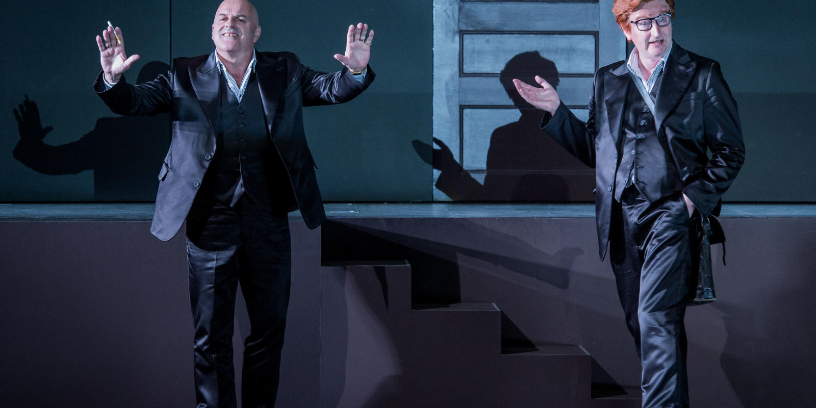 Two men standing next to each other while addressing the audience in ENO's Don Giovanni