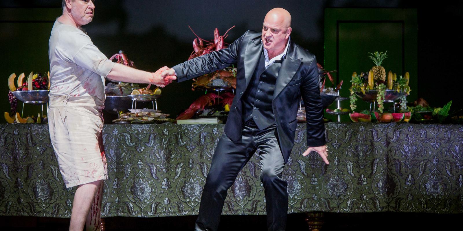 Two men shaking hands in ENO's Don Giovanni