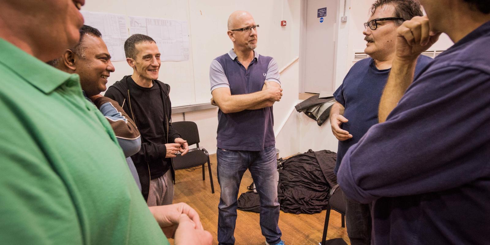 Group of men in discussion during rehearsals for ENO's Don Giovanni