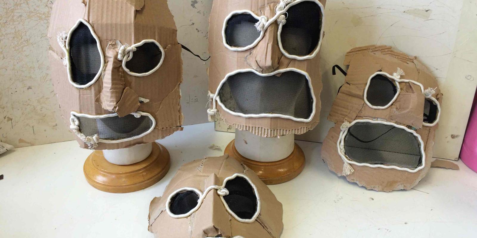 A row of cardboard masks for Don Giovanni