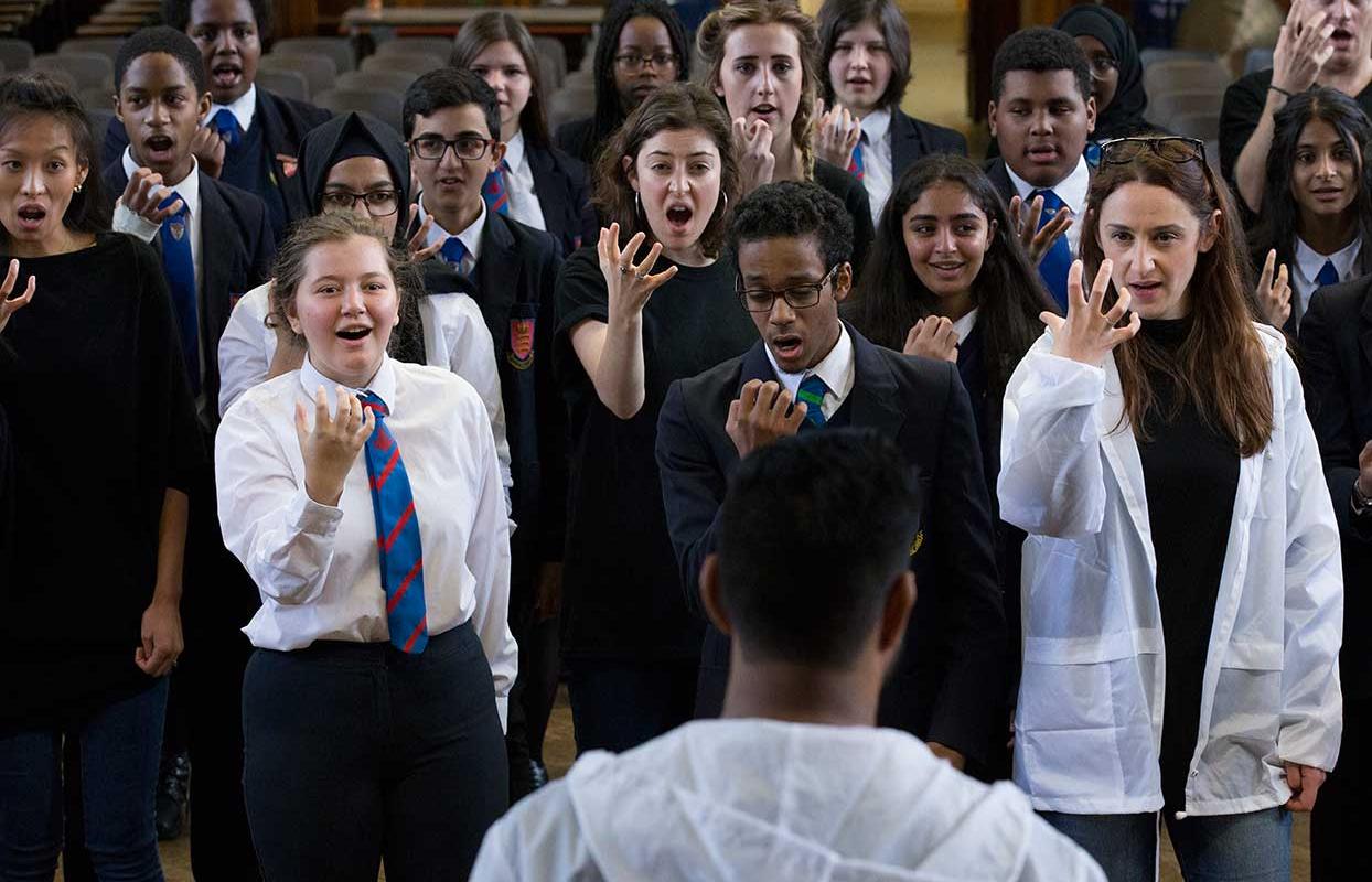 Opera squad school students facing someone with their hands open in front of their faces