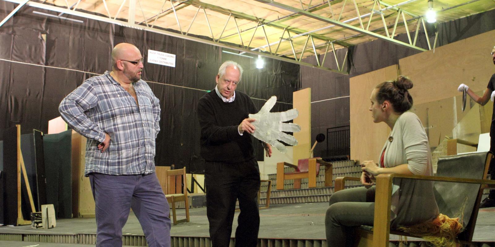 Man holding large white glove directing during rehearsals for Lulu
