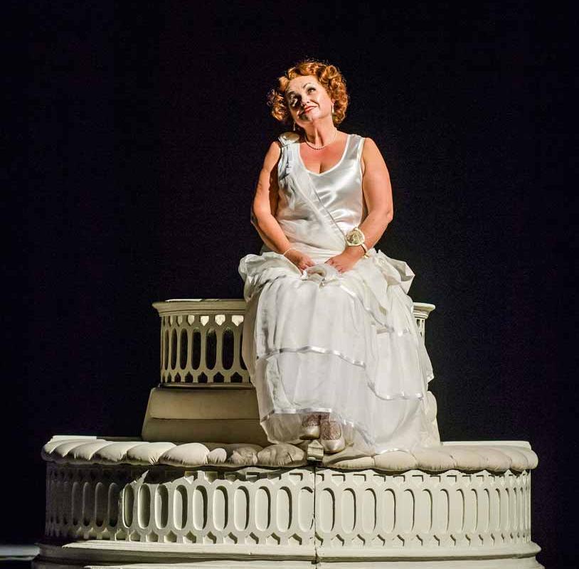 a women in a white dress sat on a fountain