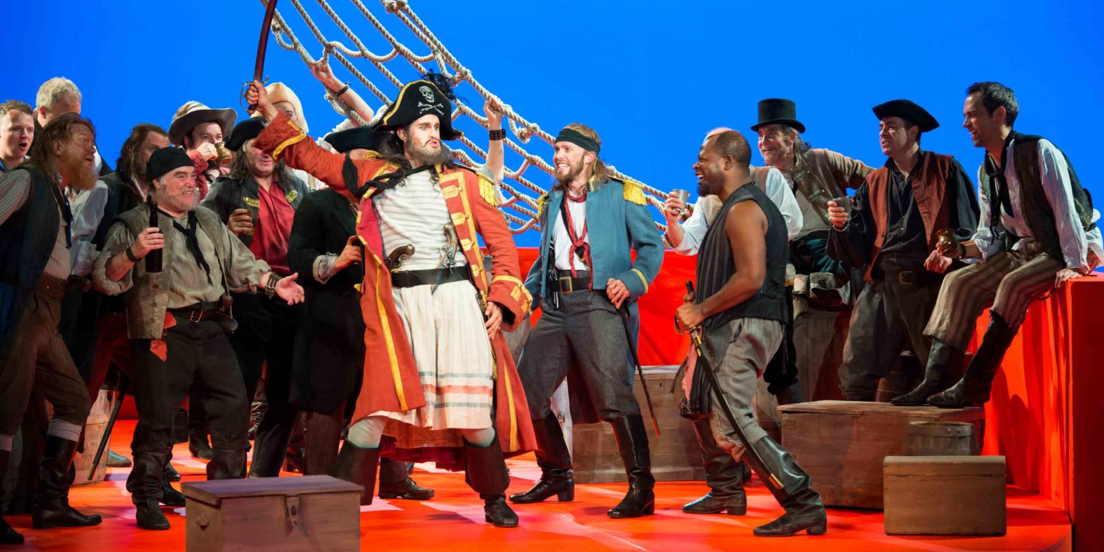 ENO's The Pirates of Penzance - Ashley Riches as The Pirate King, Johnny Herford as Samuel and ENO Chorus. Photo by Tom Bowles