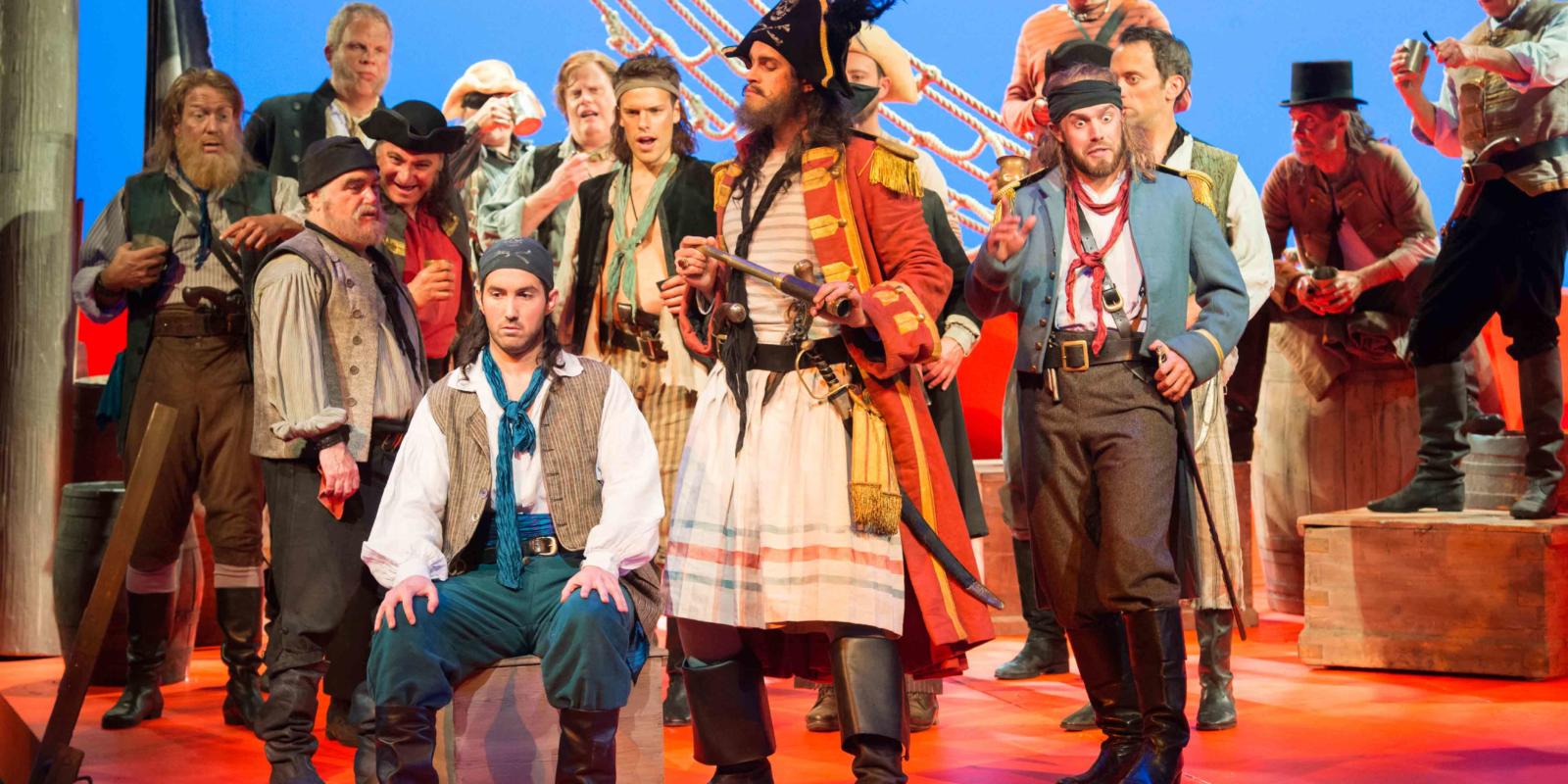 ENO's The Pirates of Penzance - David Webb as Frederic, Ashley Riches as The Pirate King, Johnny Herford as Samuel and ENO Chorus. Photo by Tom Bowles