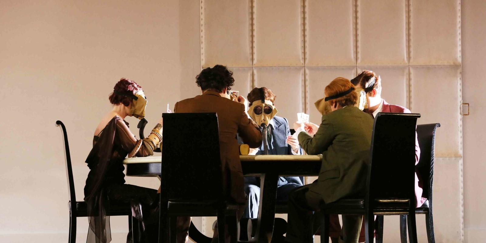 The Partenope cast playing cards at a table during ENO's 2017 production