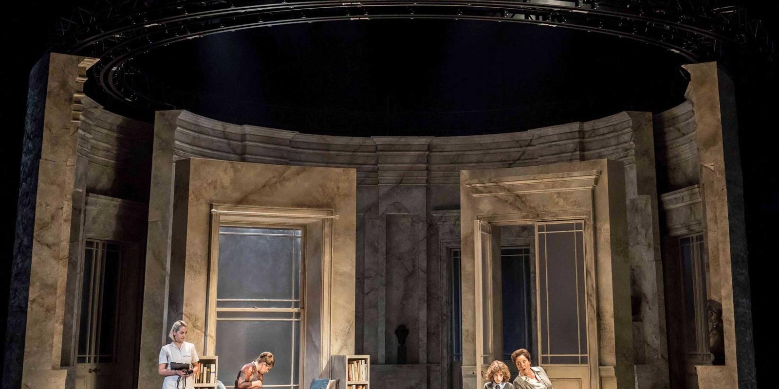 Group of women in a large circular room in ENO's The Winter's Tale