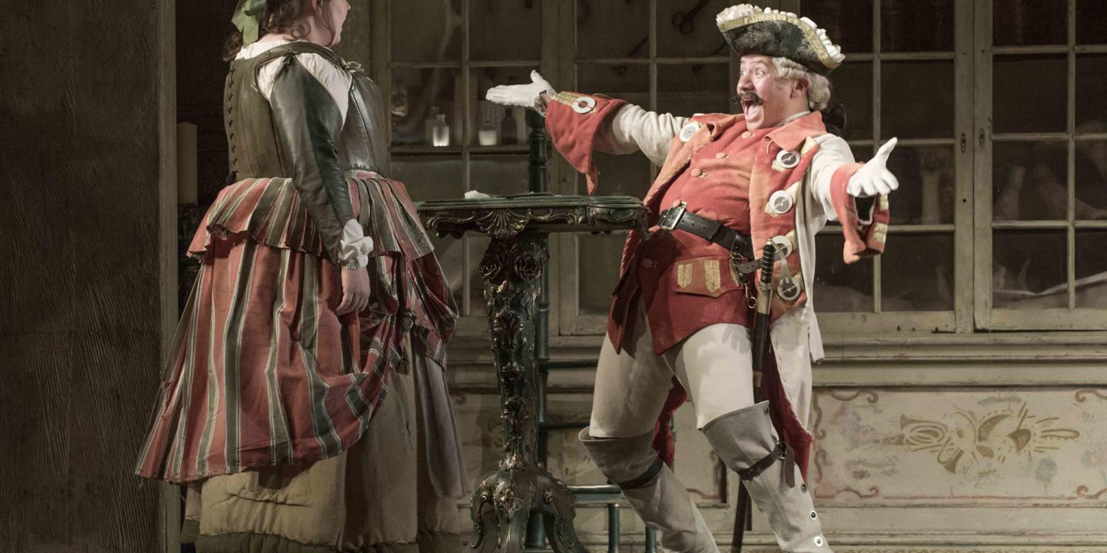 a man with his arms out wide and a happy grin, exclaiming to his friend