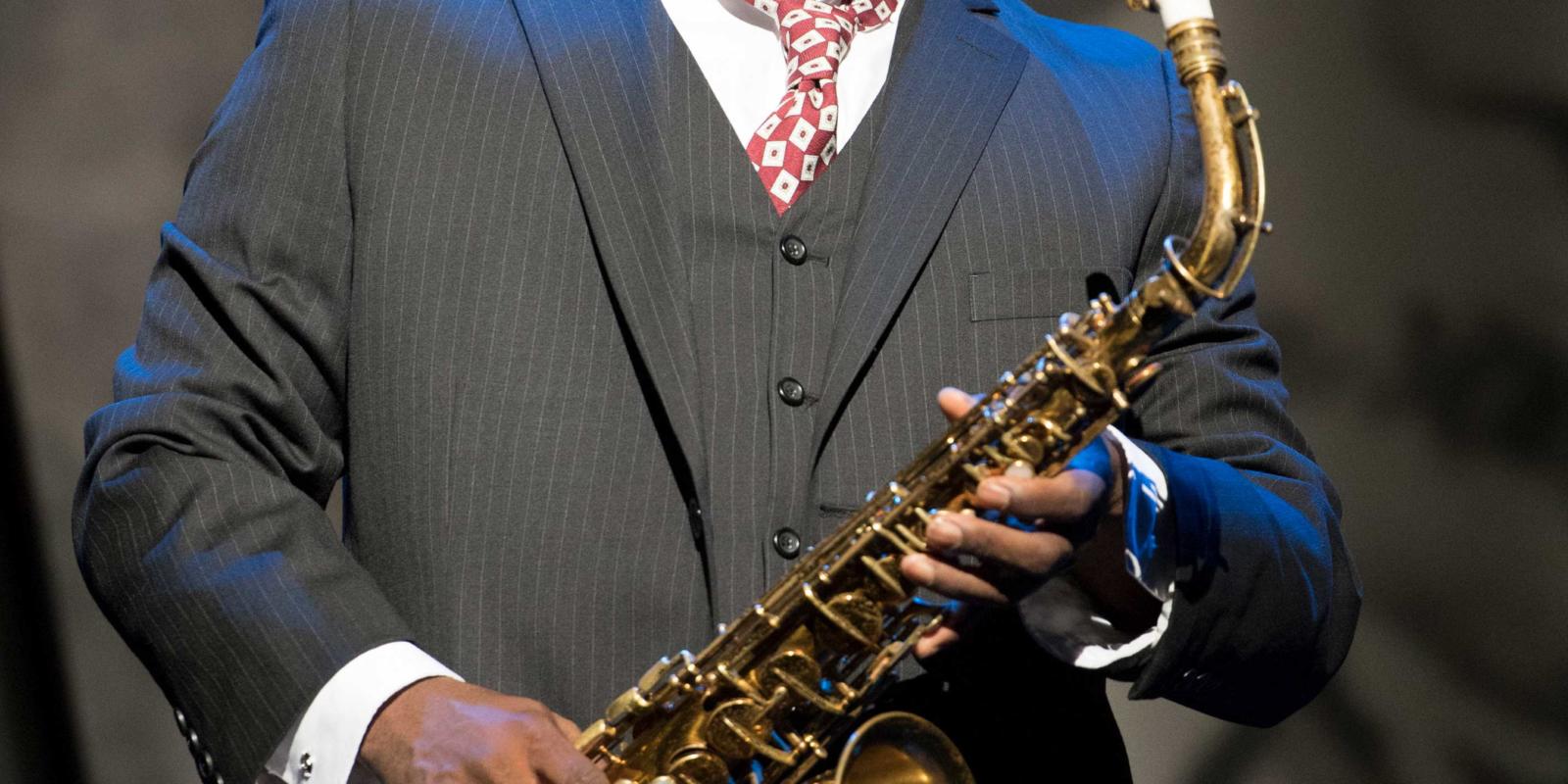man in a suit, holding his saxophone