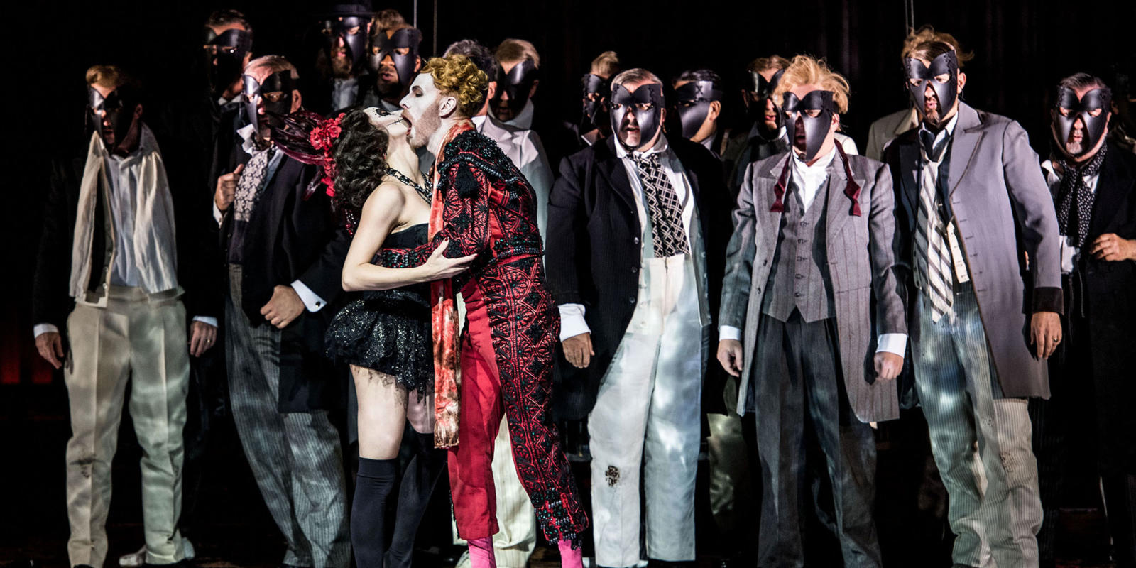 a group of people in masks, a man at the front biting a women's cheek