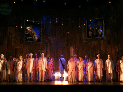 satyagraha cast performing on stage next to flame torches