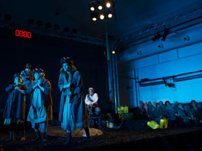 a group of people dressed in dark clothing, looking out to stage
