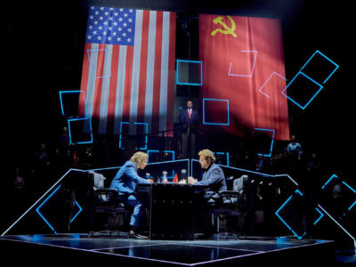 two people sat at a table with flags handing above them
