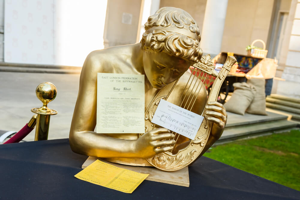 gold statue with a harp with yellow cards and music sheets placed on it from ENO's Gala