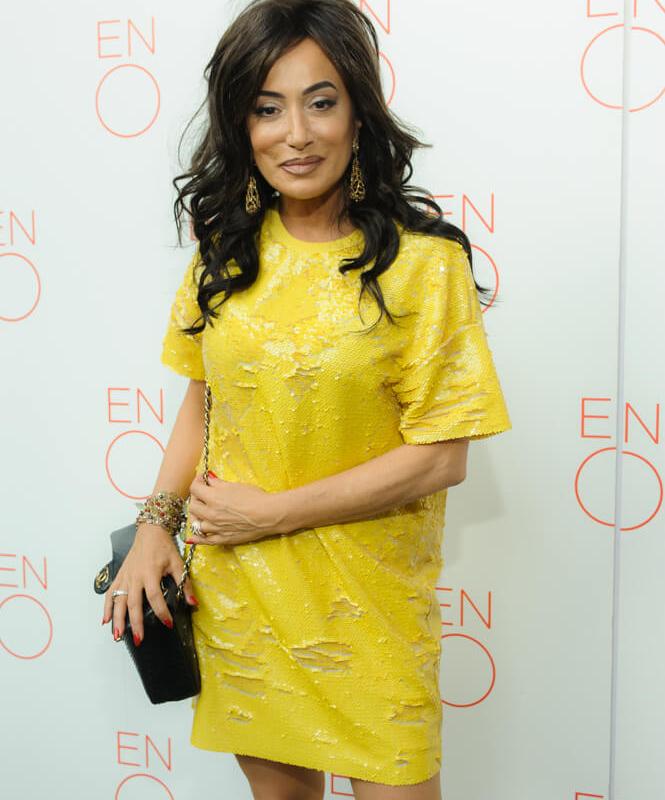 Nancy Dell'Olio in yellow dress posing for a picture at ENO's Gala Dinner