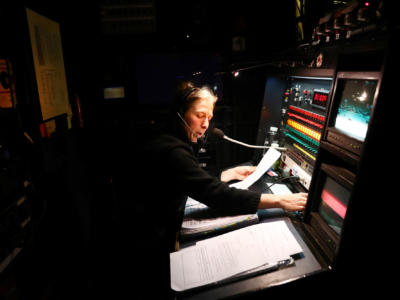 Soundman wearing a microphone at a sound desk backstage of ENO