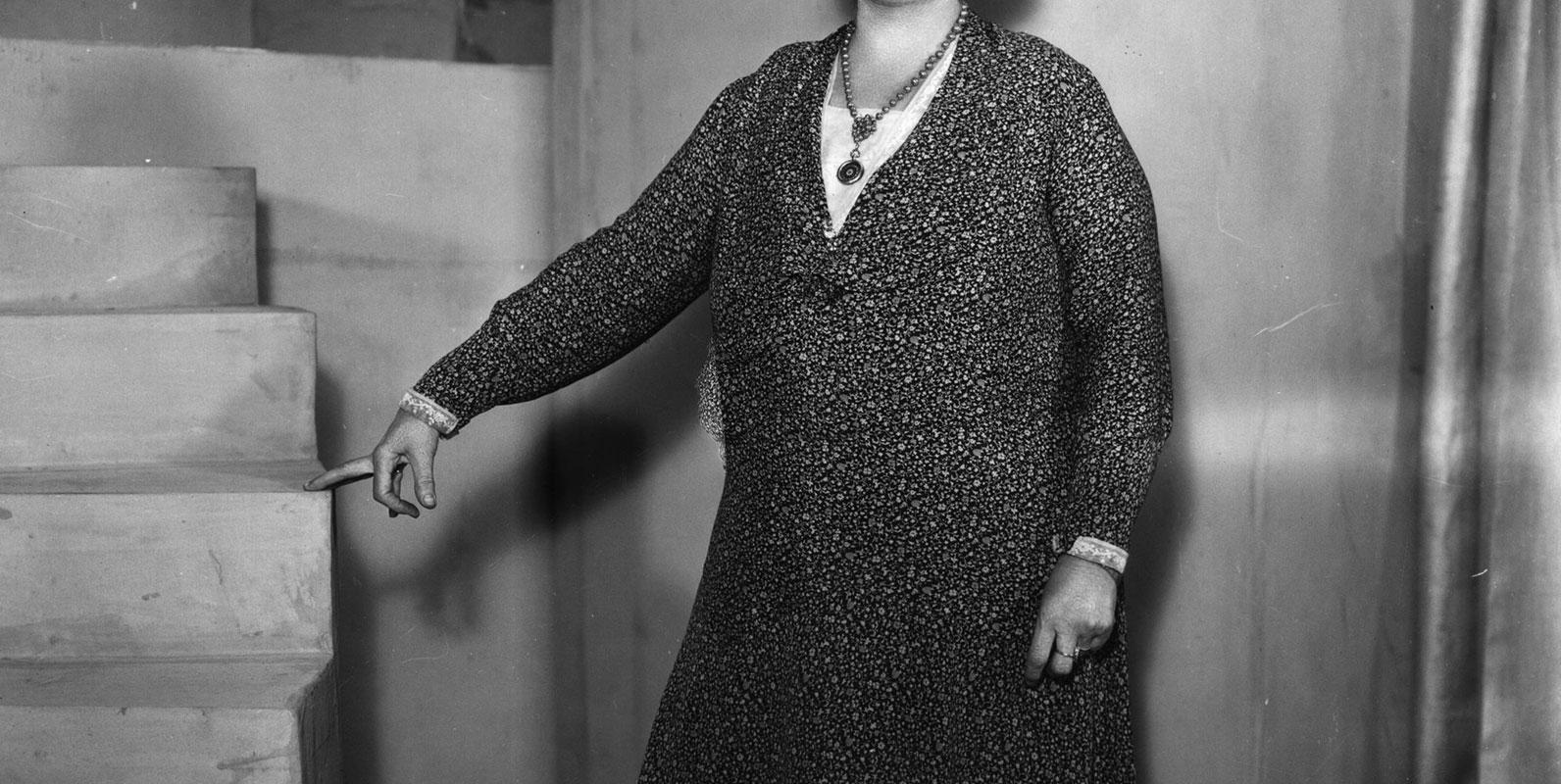 Black and white photo of Lilian Baylis standing next to steps