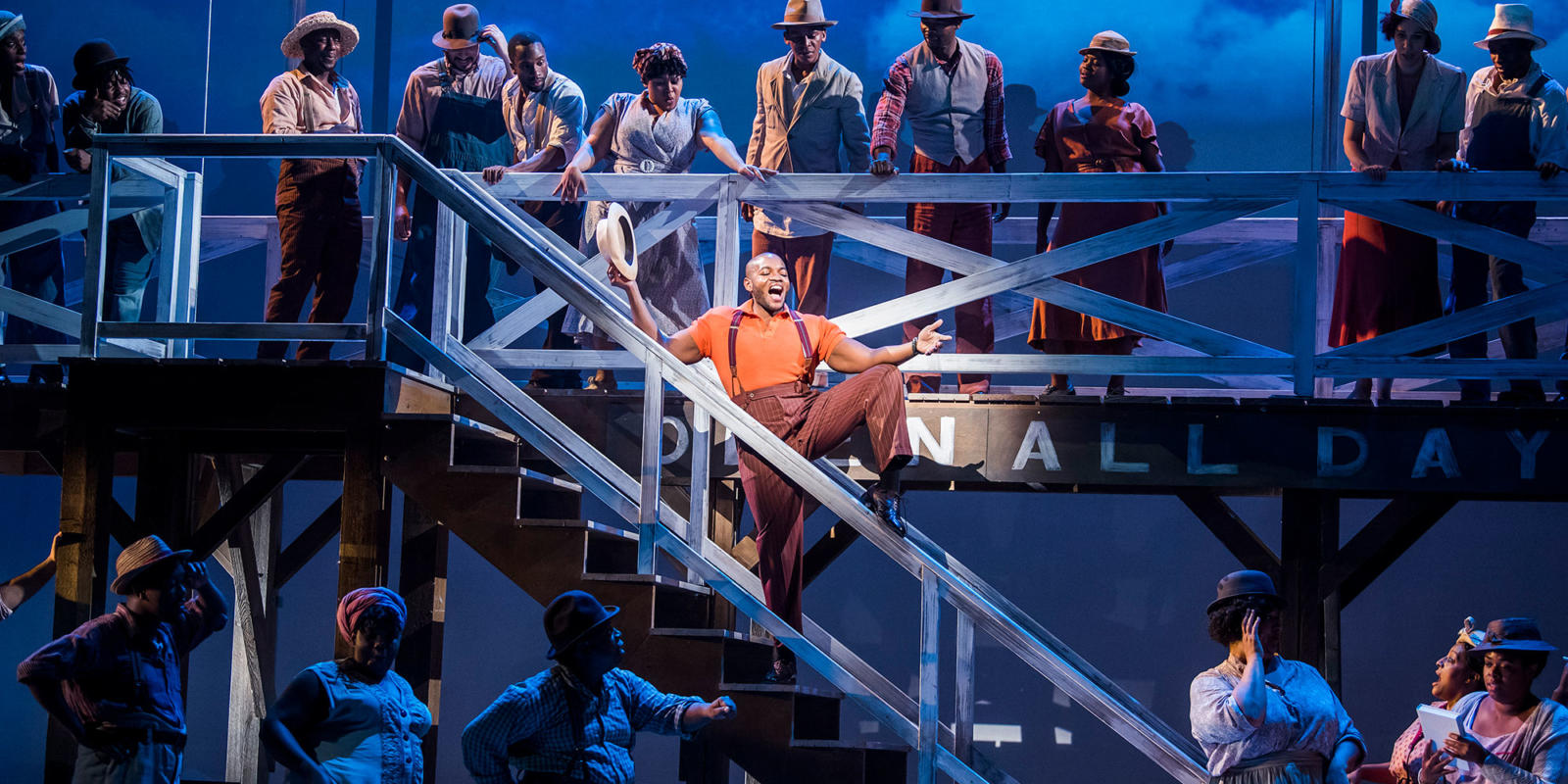 man singing on staircase surrounded by cast in Porgy and Bess