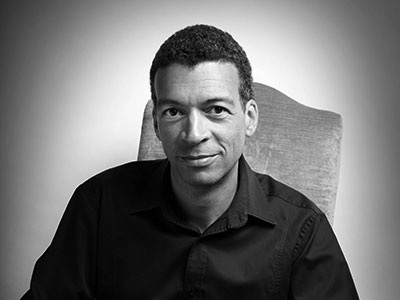 Black and white portrait of Roderick Williams sitting on a chair
