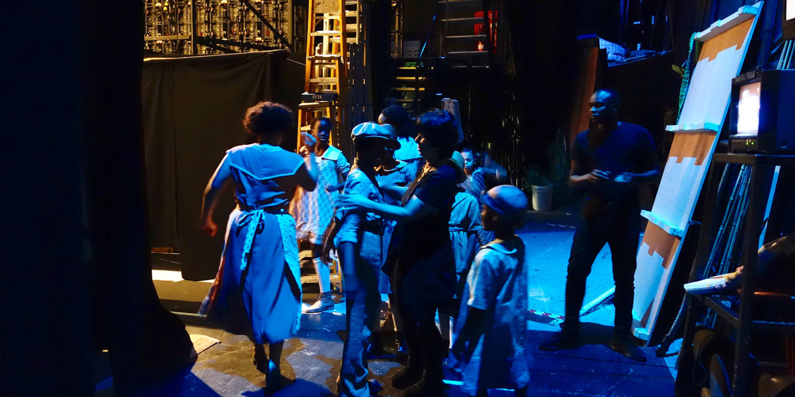 Members of the Children's Chorus play with one another in the wings