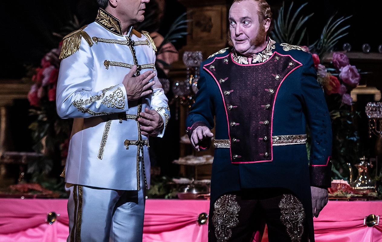 two men dressed in royal suits, looking at each other
