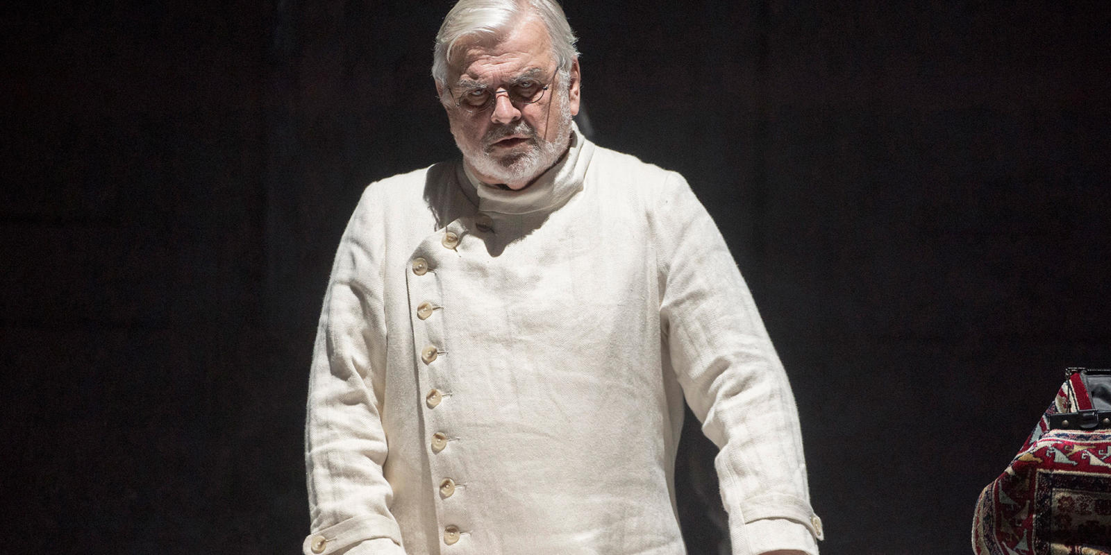 a man in white looking towards the stage