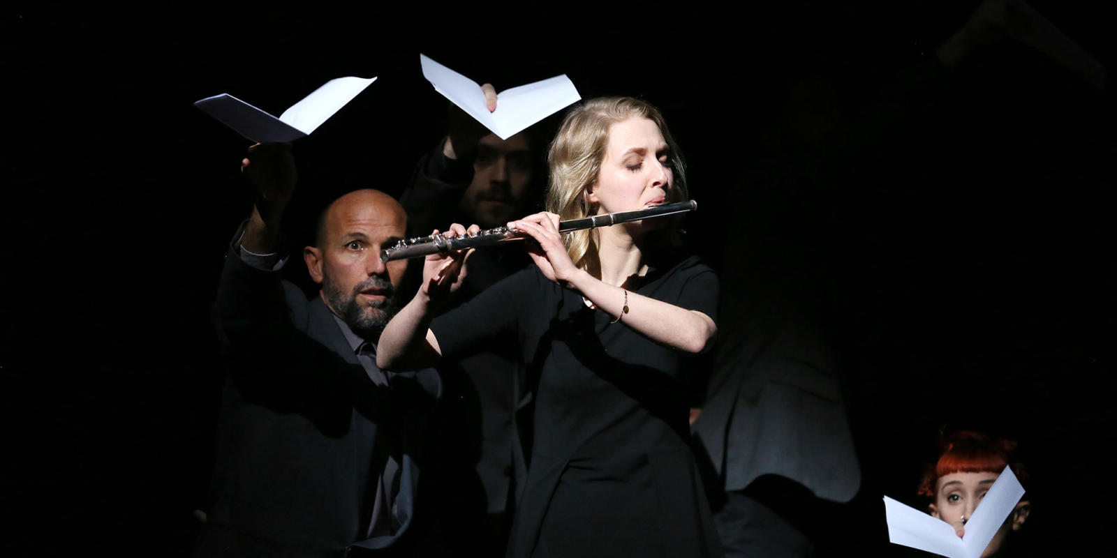 Blonde woman playing the flute on stage