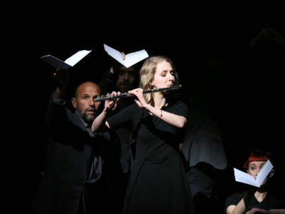 Blonde woman playing the flute on stage