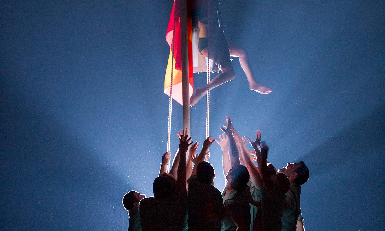Members of the ensemble raise the Spanish flag