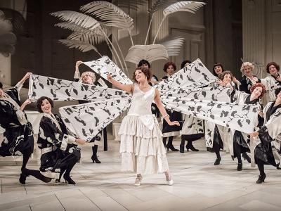 Yum-Yum posing in front of poised dancers holding flags