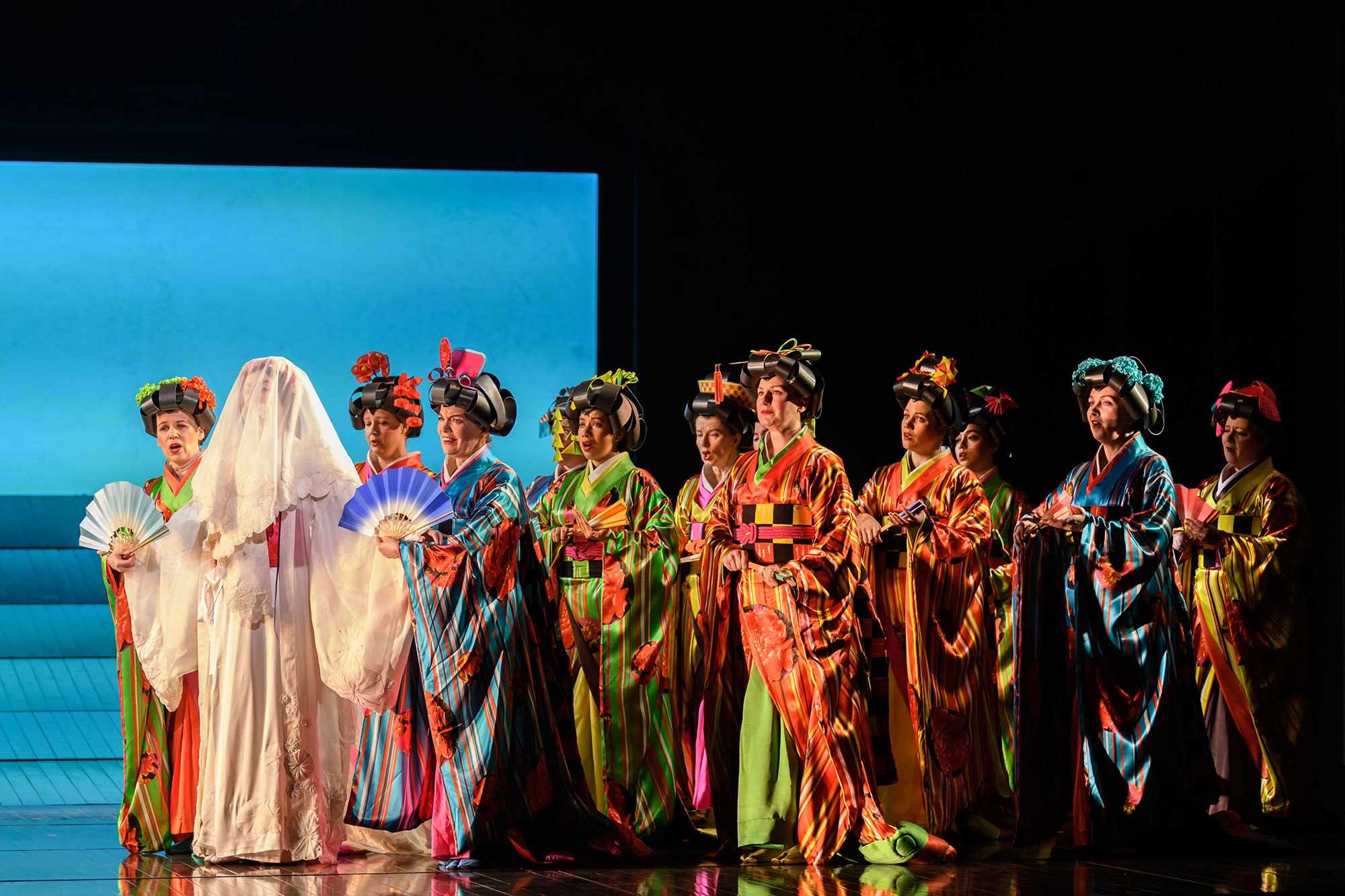 Women in Japanese dress stand around a veiled Cio-Cio San