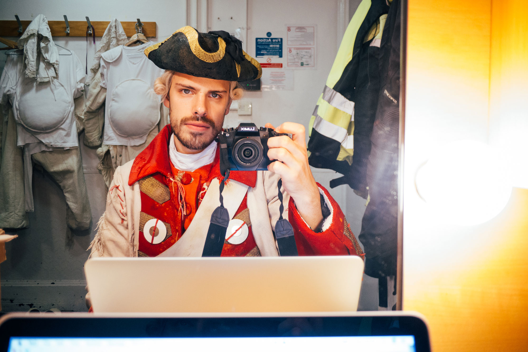 man taking a picture in the mirror: wearing a pirate costume