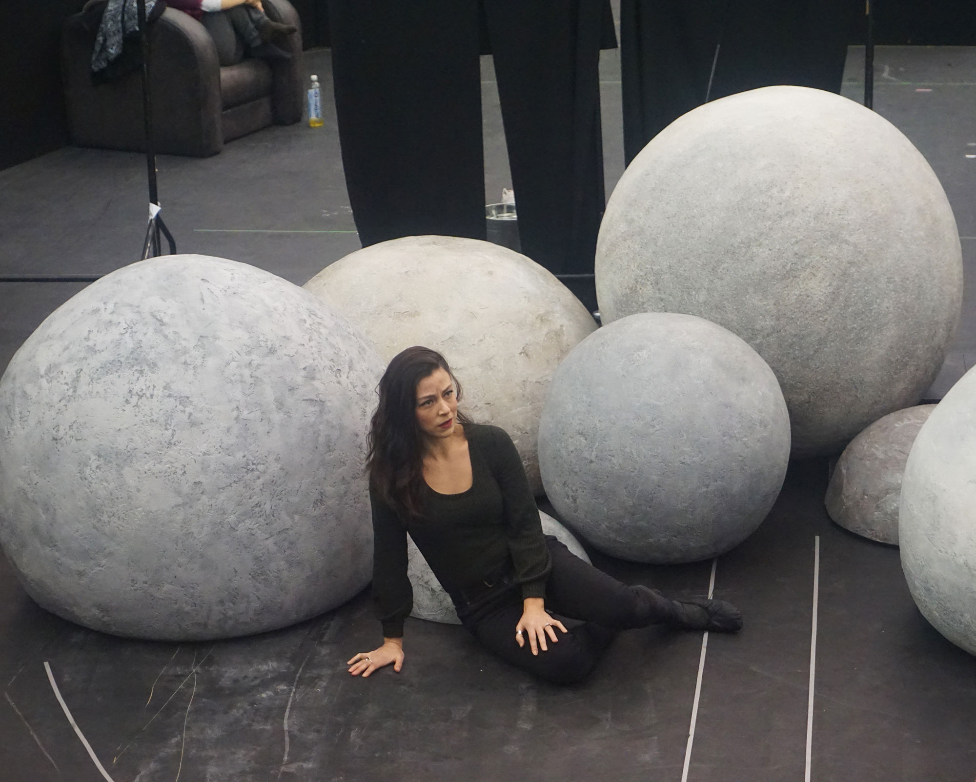 woman sat next to white spherical shaped props