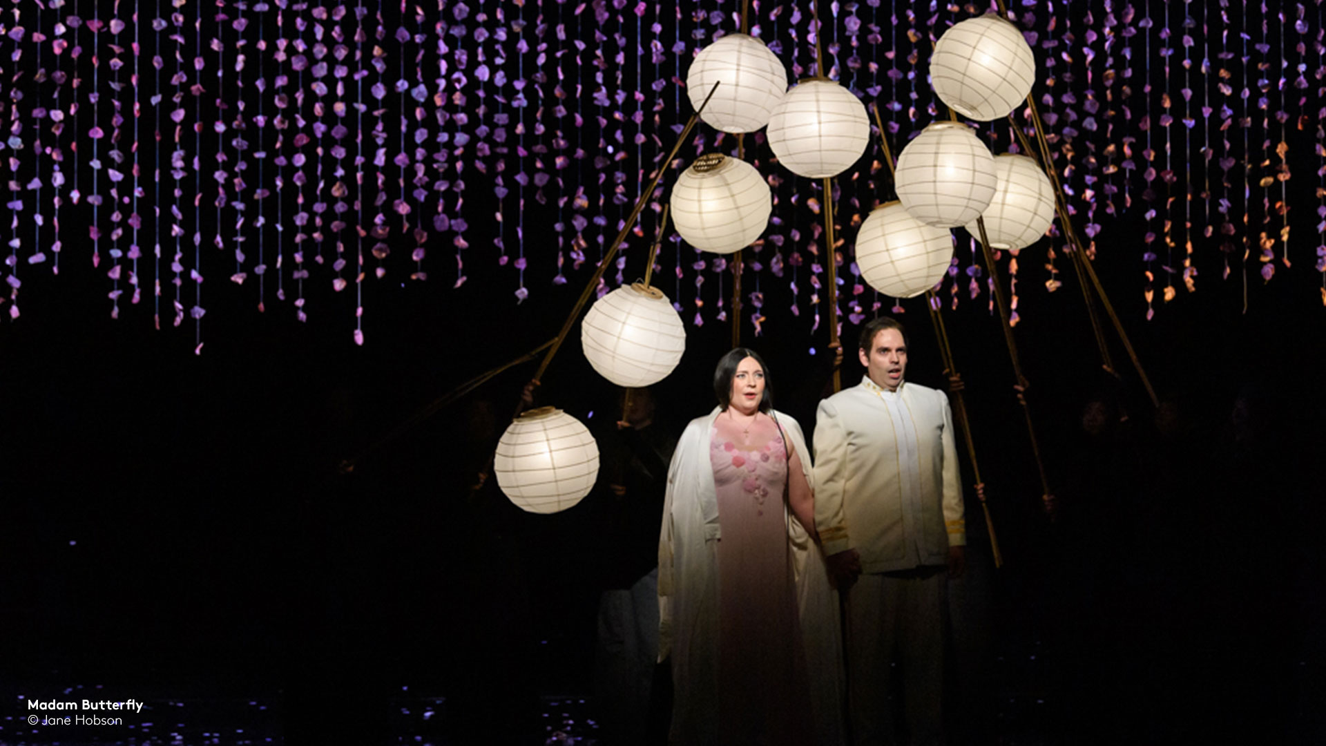 still from madam butterfly with man and woman surrounded by white lamps