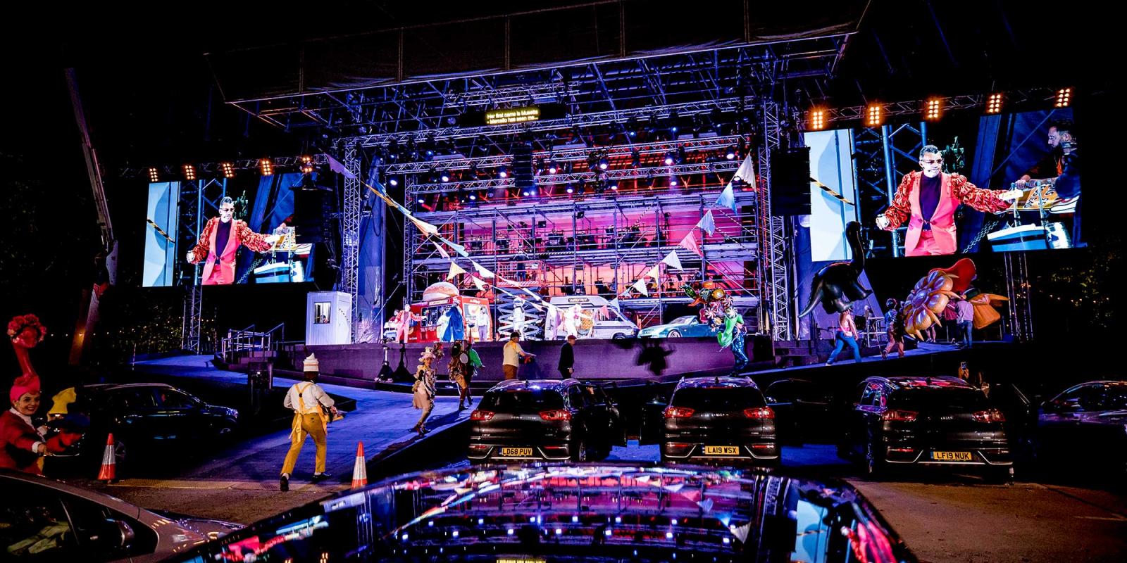 The Drive & Live car park and stage with Marcello on screens flanking the stage.