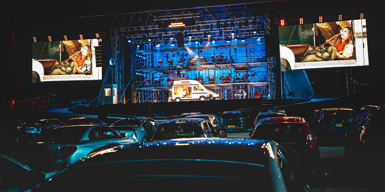 The Drive & Live car park and stage, showing Mimi on screens flanking the stage.