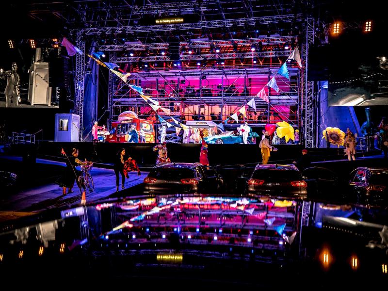 Drive & Live stage with food vans and flower sellers on stage.