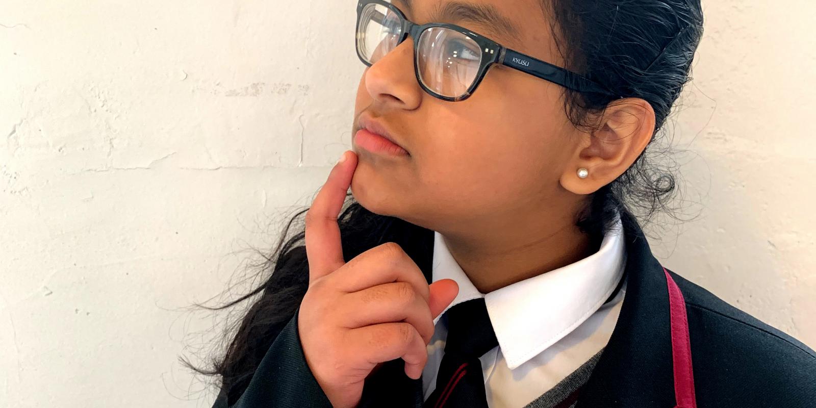 school girl with finger on chin as if inquisitively thinking