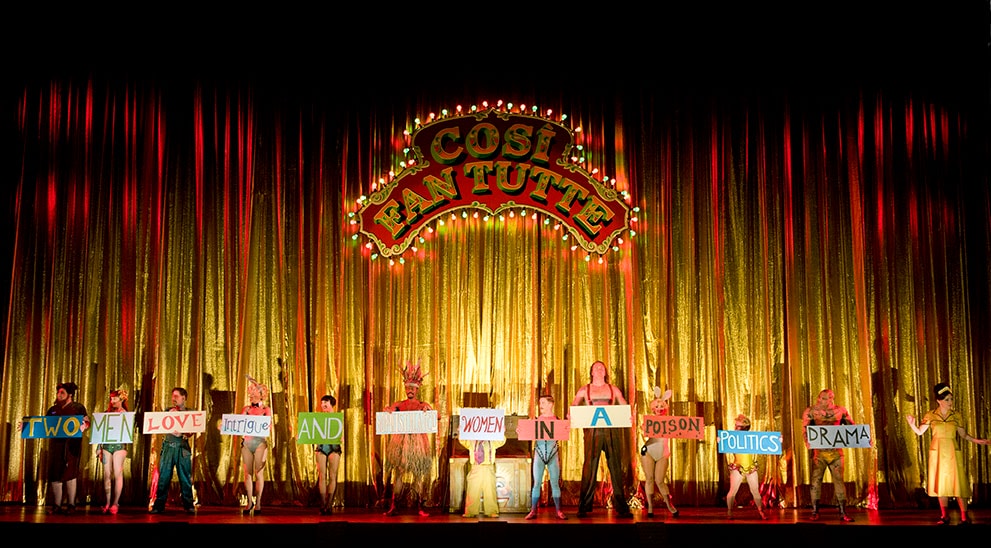 The cast hold signs saying: Two Men Love Intrigue And Sophisticated Women In A Poison Politics Drama